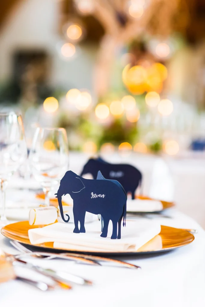 Individuelle Hochzeitspapeterie im Schloss Elmau in Bayern mit handgeschnittenen Elefanten als Tischkarten, kombiniert mit dunkelblauem Aquarell und Goldakzenten